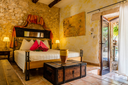 Finca Can Duvai_Superior_Garten_Apartment_Orangenzimmer_Bett.webp